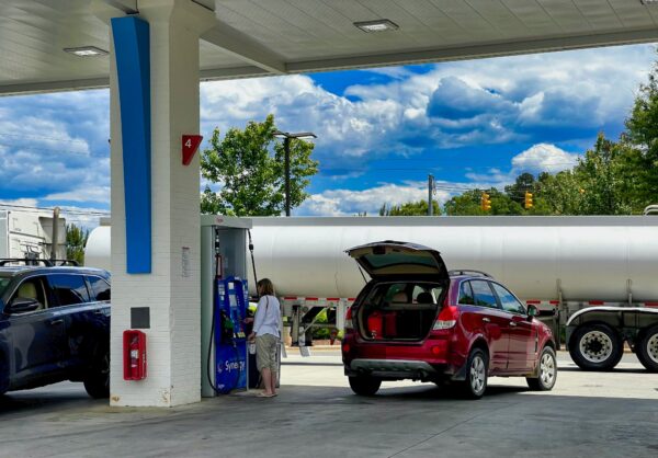 A motorist and a gas station refuel.
