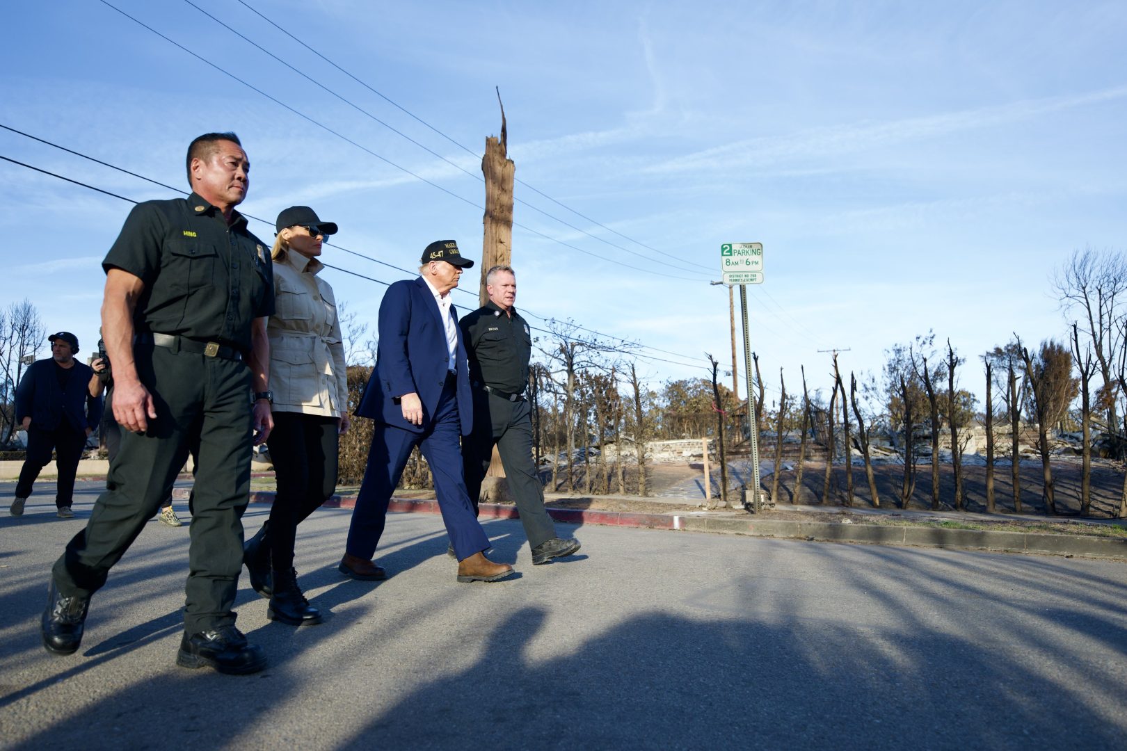 President Donald Trump, third from left, walks with first lady Melania Trump and local officials through a fire-ravaged neighborhood in Pacific Palisades.