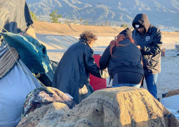 An individual living in an encampment speaks with 2024 Point-in-Time Count participants.