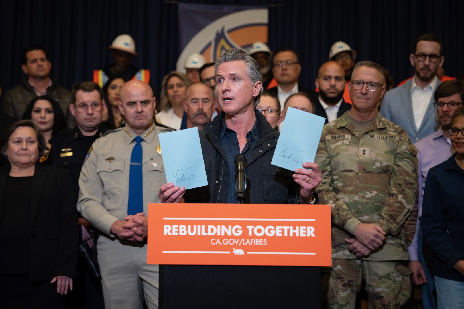 Gov. Gavin Newsom displays signed legislation for $2.5 billion in wildfire relief funds.