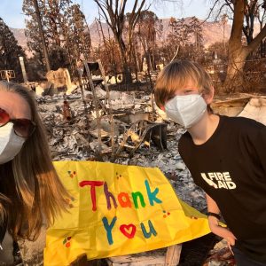 Kelsey Brown and her son Calder thanking first responders in front of the remains of their Altadena home.