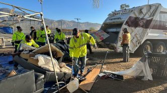 A crew of workers clears an encampment in December at Wildwood Park in San Bernardino.