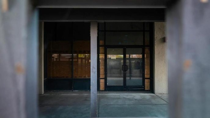 A shuttered door remains at a homeless shelter in Anaheim that is permanently shut down and partially boarded up.