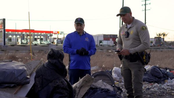 San Bernardino County Supervisor Joe Baca Jr., middle, and a sheriff's deputy speak a person experiencing homelessness during the 2025 point-in-time count.