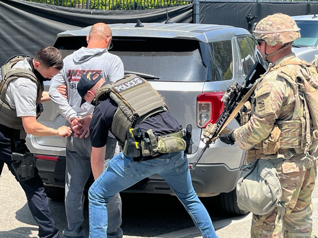 Immigration agents accompanied by a federalized National Guard soldier detain a man June 10, 2025, in Los Angeles.