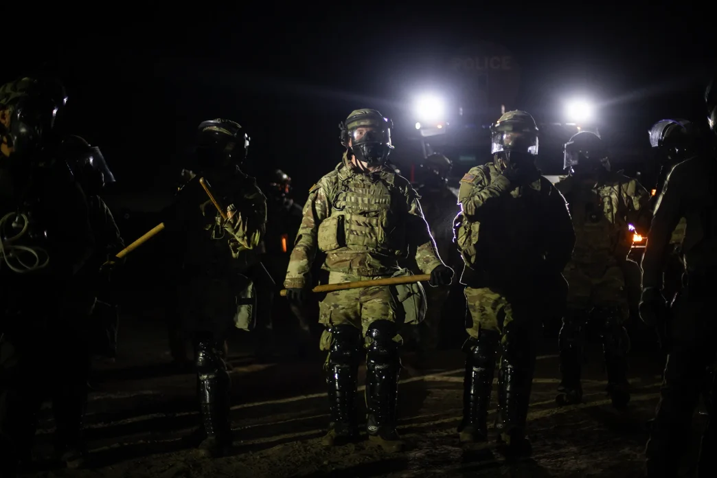 A line of federal immigration agents faces protesters in a stand-off near the Glass House Farms facility near Camarillo on July 10.