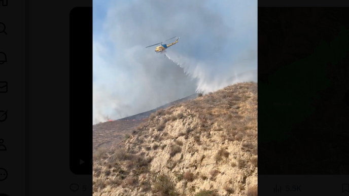A helicopter drops water on the Canyon Fire near the Ventura and Los Angeles county line.