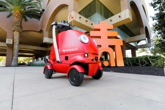 A DoorDash delivery robot arrives at Riverside City Hall.