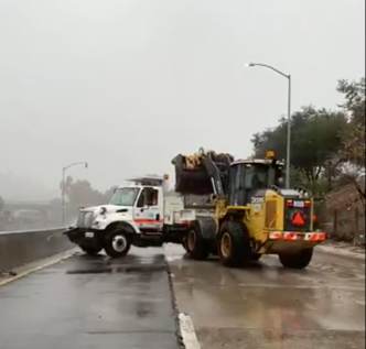 Caltrans vehicles clear mud from the 110 Freeway near Avenue 43 in Montecito Heights.