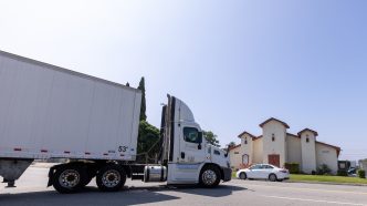 A semitruck leaves a warehouse across the street from St. Mark’s Missionary Baptist Church on June 8 in San Bernardino.