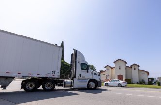 A semitruck leaves a warehouse across the street from St. Mark’s Missionary Baptist Church on June 8 in San Bernardino.