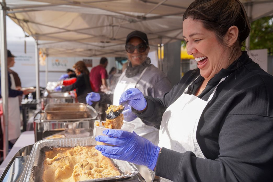 A Union Station Homeless Services volunteer serves mashed potatoes at Dinner in the Park in 2024.