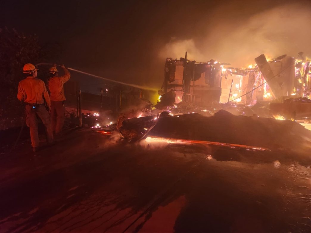 Firefighters spraying water from a hose during the Eaton Fire.