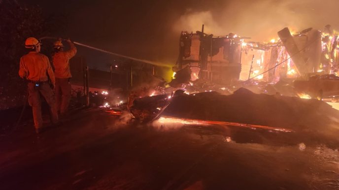 Firefighters spraying water from a hose during the Eaton Fire.