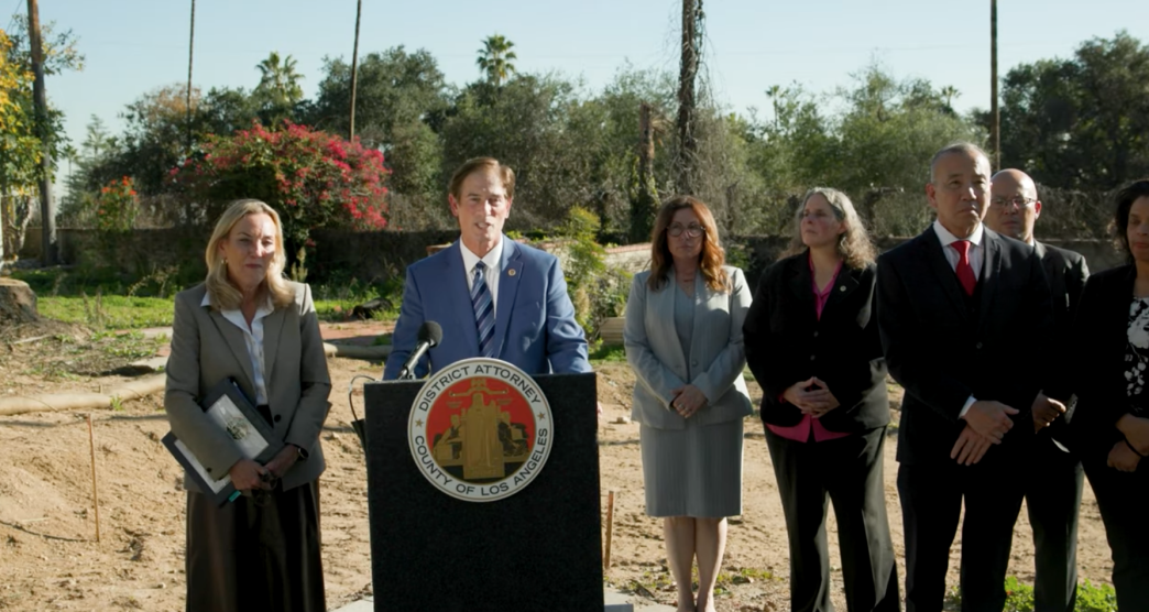 District Attorney Nathan Hochman, at podium, with LA County District 3 Supervisor Kathryn Barger and other county officials, announce charges against unlicensed contractors operating in the Eaton Fire zone.