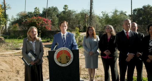 District Attorney Nathan Hochman, at podium, with LA County District 3 Supervisor Kathryn Barger and other county officials, announce charges against unlicensed contractors operating in the Eaton Fire zone.