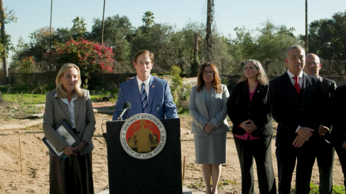 District Attorney Nathan Hochman, at podium, with LA County District 3 Supervisor Kathryn Barger and other county officials, announce charges against unlicensed contractors operating in the Eaton Fire zone.
