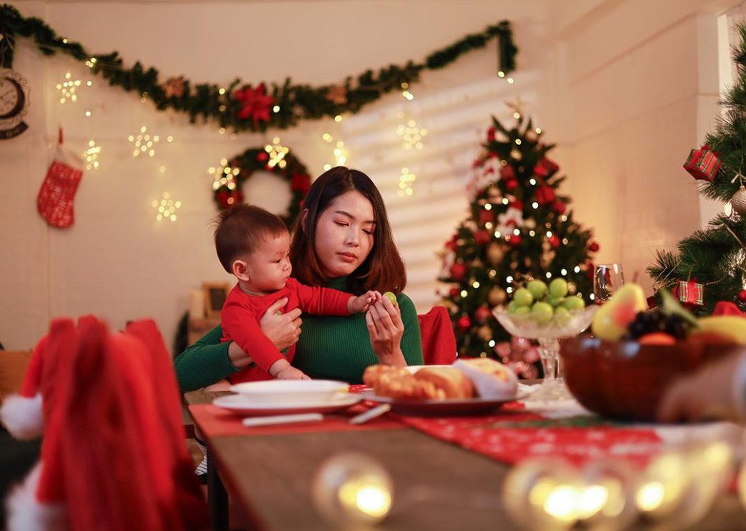 A woman and a baby at a holiday table.