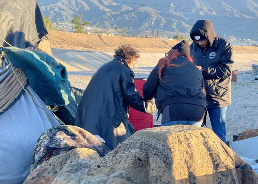 Volunteers speak with an individual experiencing homelessness during the 2024 Point-in-Time Count.