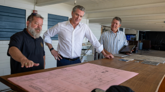 Gov. Gavin Newsom, at center, and an unidentified man meet in Malibu with Jim Harris, at left, who is general manager & CEO of Gladstones Restaurant.