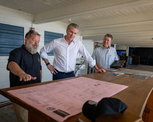 Gov. Gavin Newsom, at center, and an unidentified man meet in Malibu with Jim Harris, at left, who is general manager & CEO of Gladstones Restaurant.