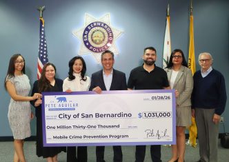 Rep. Pete Aguilar, D-San Bernardino, fourth from left, presents city officials with a ceremonial check for more police surveillance equipment.
