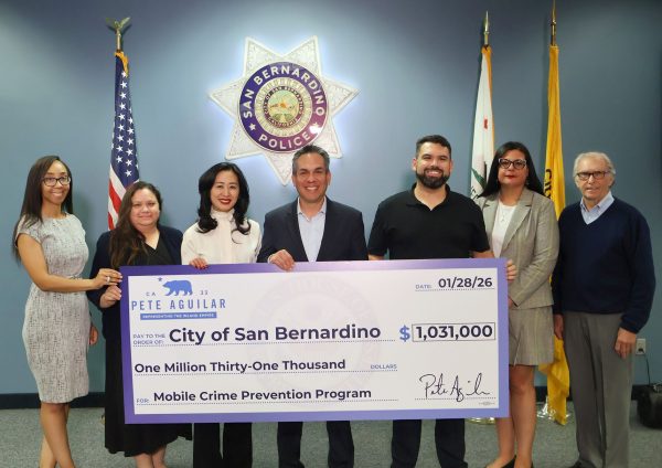 Rep. Pete Aguilar, D-San Bernardino, fourth from left, presents city officials with a ceremonial check for more police surveillance equipment.