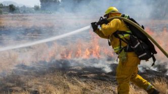 A Riverside firefighter battles a brush fire.