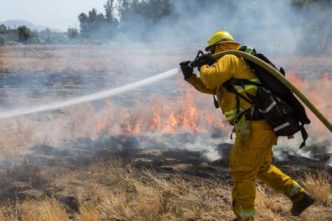 A Riverside firefighter battles a brush fire.
