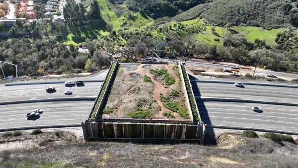 An aerial view of the in-progress construction of the Wallis Annenberg Wildlife Crossing over the 101 Freeway.