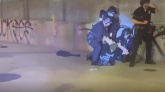 LAPD officers arrest a man during an anti-ICE protest in downtown LA late Saturday, Jan. 31, 2026.