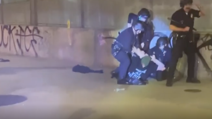 LAPD officers arrest a man during an anti-ICE protest in downtown LA late Saturday, Jan. 31, 2026.