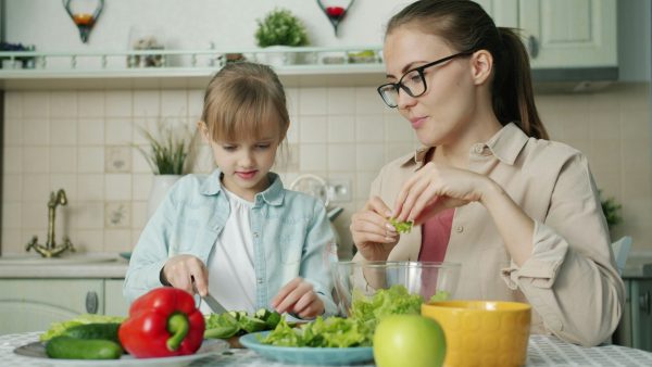 A woman and young girl prepare lunch.