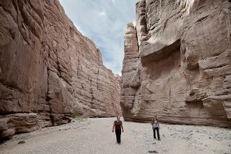 Hikers stroll through a steep-walled canyon in the Mecca Hills Wilderness, part of the Chuckwalla National Monument in Riverside County.