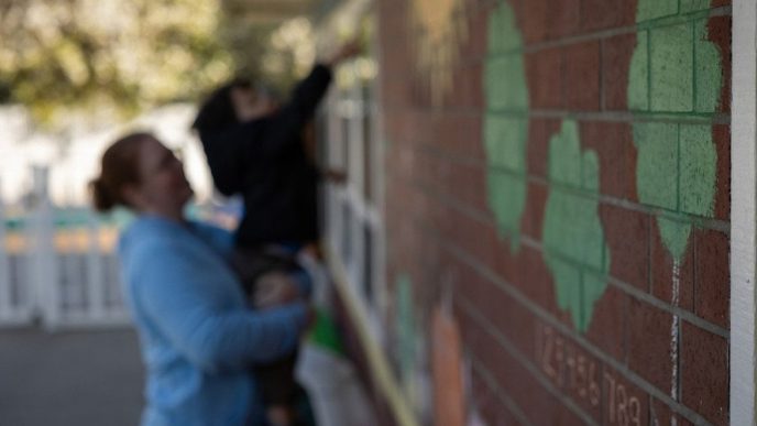 In the background, Amanda Smith, a behavioral specialist, holds up a child outside the Moore Learning Preschool & Childcare Center in Elk Grove on Feb. 6, 2026.