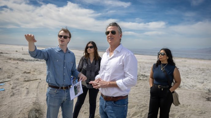 Gov. Gavin Newsom, third from left, and officials survey the dried areas of the Salton Sea ahead of a newly formed local conservancy.