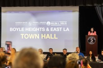 Supervisor Hilda Solis, at podium, speaks during a town hall meeting in Boyle Heights following a massive warehouse fire that is still emitting foul-smelling, possibly toxic fumes.