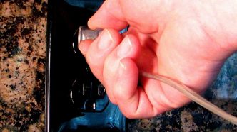 Plugging an appliance into an electrical outlet.