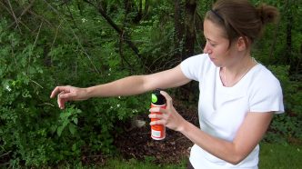A woman applies insect repellent.