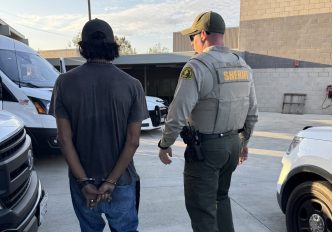 A deputy takes into custody one of the 25 individuals arrested during Operation Shelter Me Aug. 21, 2026, in Rancho Cucamonga.