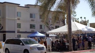 Attendees of a recent community event in San Bernardino at 450 N. G St. gather in front of the supportive housing complex.