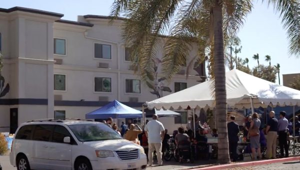 Attendees of a recent community event in San Bernardino at 450 N. G St. gather in front of the supportive housing complex.