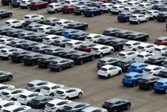 Cars for sale occupy an auto dealership lot.