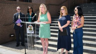 District 5 Supervisor Kathryn Barger announces a lawsuit against State Farm. From left, Assistant County Counsel Scott Kuhn, County Counsel Dawyn Harrison, Barger at podium, Supervisor Lindsey Horvath and fire survivor advocate Joy Chen.