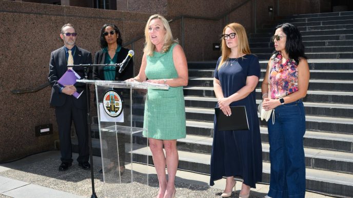 District 5 Supervisor Kathryn Barger announces a lawsuit against State Farm. From left, Assistant County Counsel Scott Kuhn, County Counsel Dawyn Harrison, Barger at podium, Supervisor Lindsey Horvath and fire survivor advocate Joy Chen.