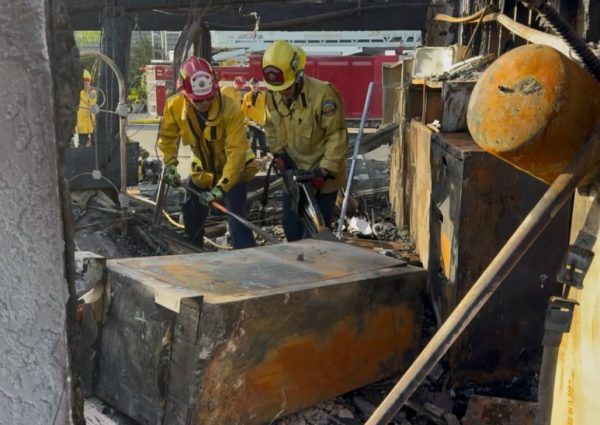 Firefighters go through a destroyed home Saturday during the Norte Fire.