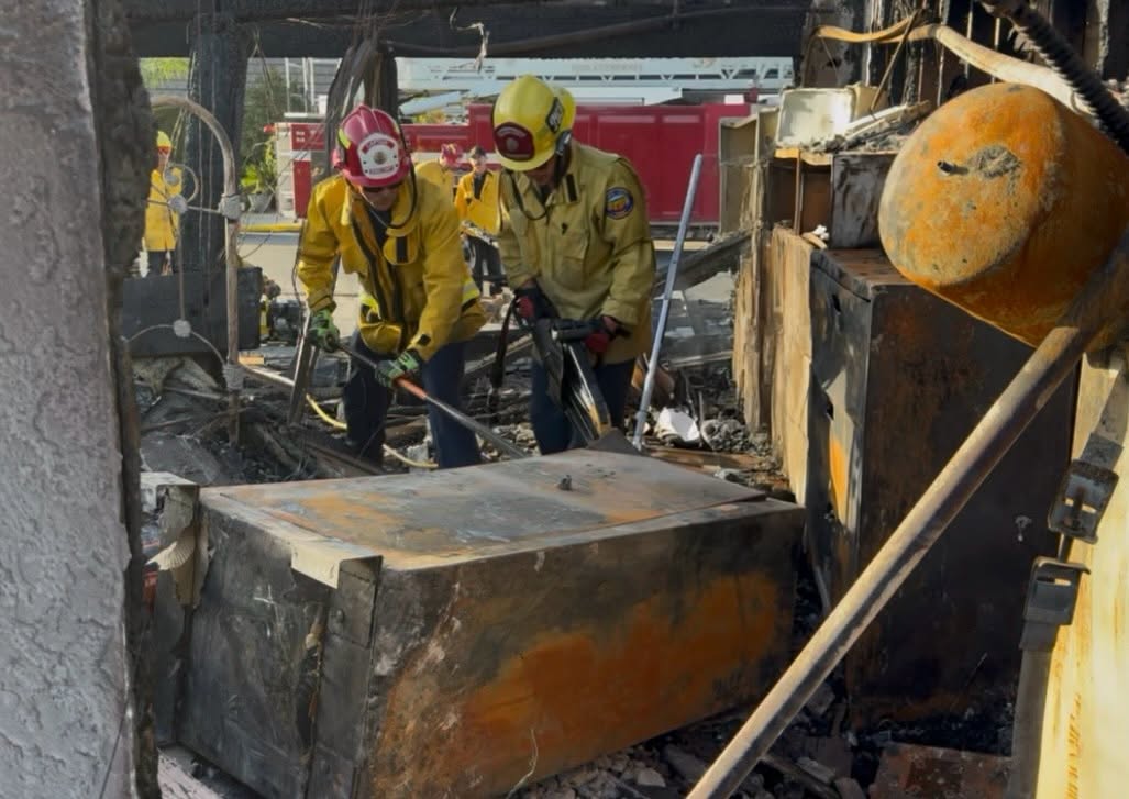 Firefighters go through a destroyed home Saturday during the Norte Fire.